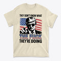 T-shirt featuring the quote 'They Don't Know What The Fuck They're Doing' with an American flag backdrop.