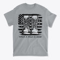 Walk A Mile In Mine Apparel Art featuring military boots on a grey t-shirt with an American flag design.