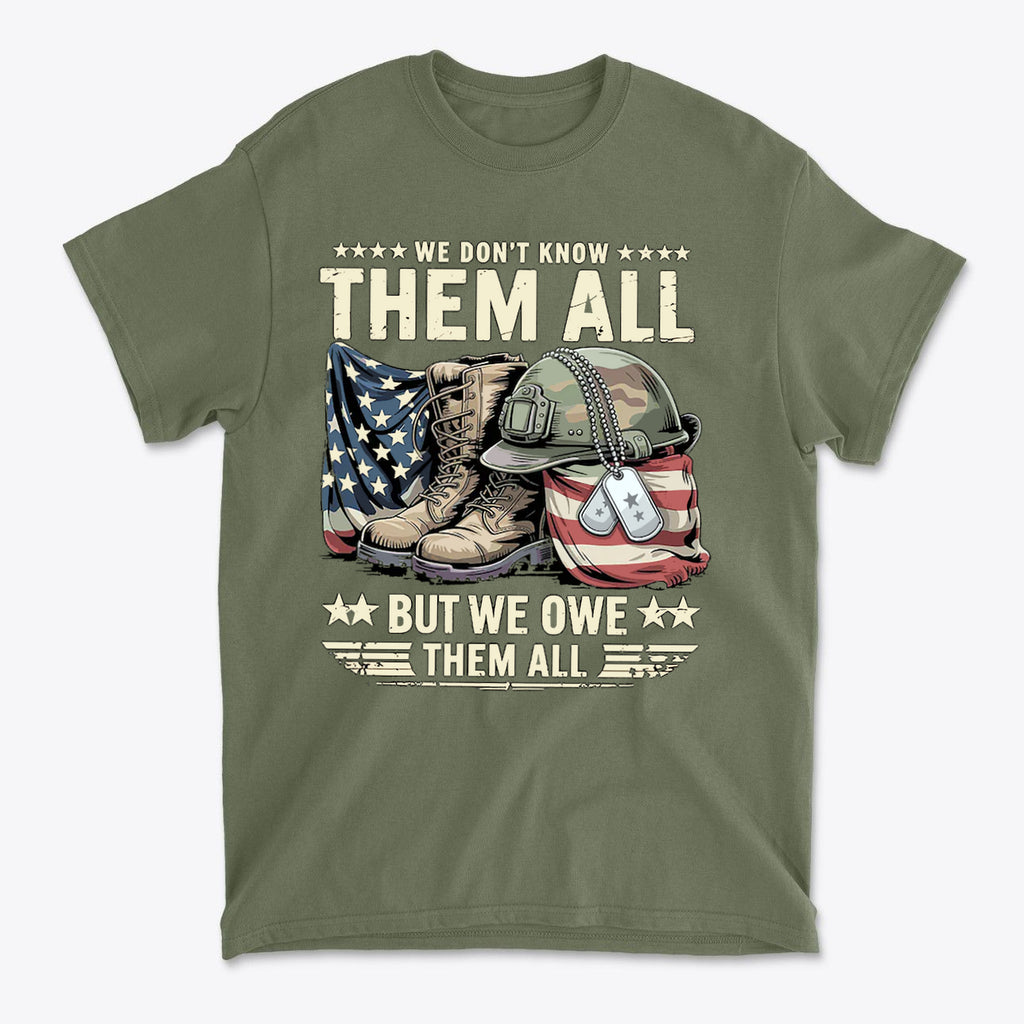 We Don't Know Them All But We Owe Them All graphic t-shirt featuring military boots, helmet, and American flag.