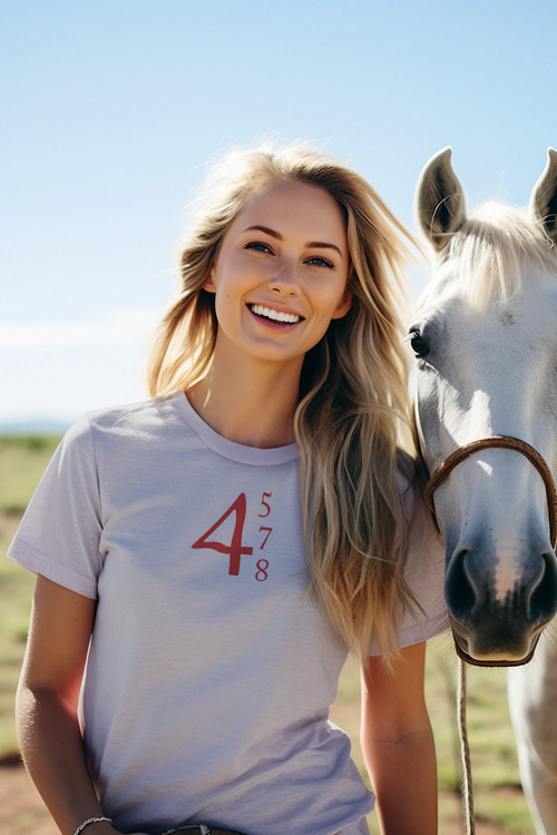 Smiling woman wearing a t-shirt with 45 47 48 Red Letters Custom Print graphic, standing next to a horse in bright outdoor setting.