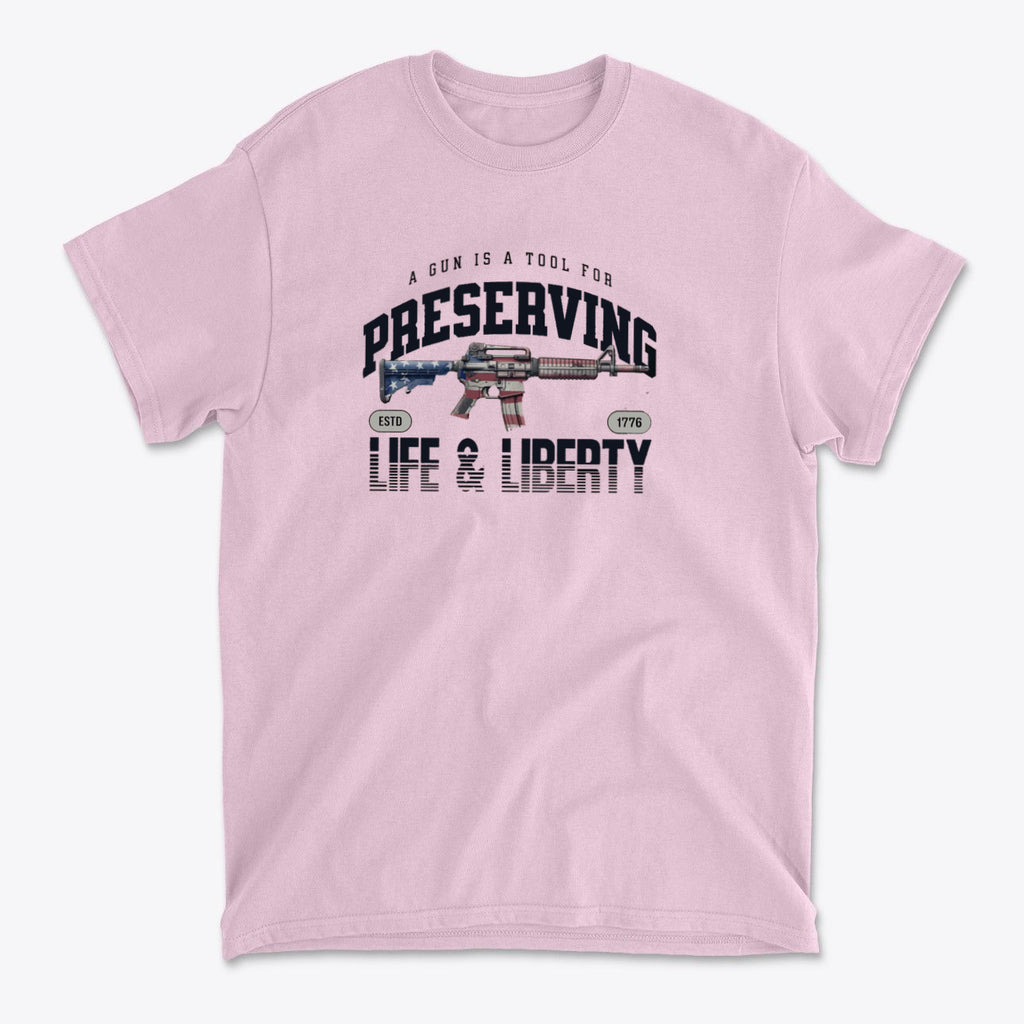 Graphic tee featuring the phrase A Gun Is A Tool For Preserving Life and Liberty on a pink background.