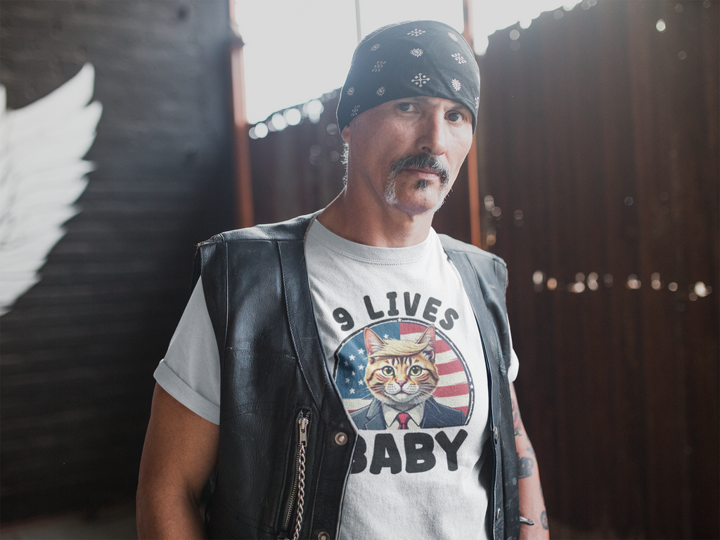 Man wearing a Nine Lives US Flag Round Design t-shirt with a cat graphic, expressing patriotic support.