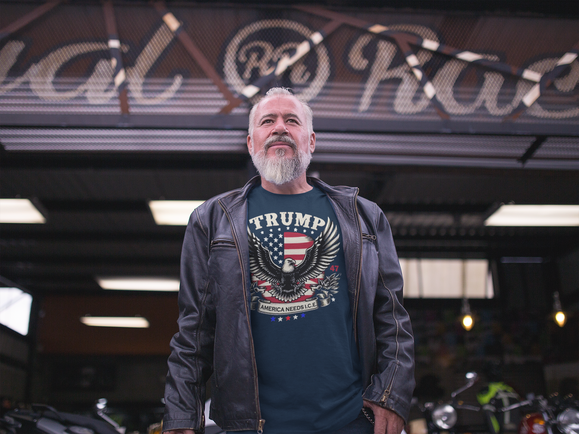 Man wearing a graphic tee with the slogan "Why America Needs ICE For Order" in a motorcycle shop.