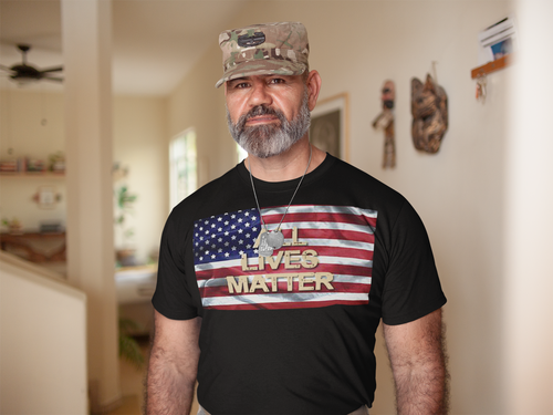 Man wearing All Lives Matter On American Flag t-shirt standing indoors.