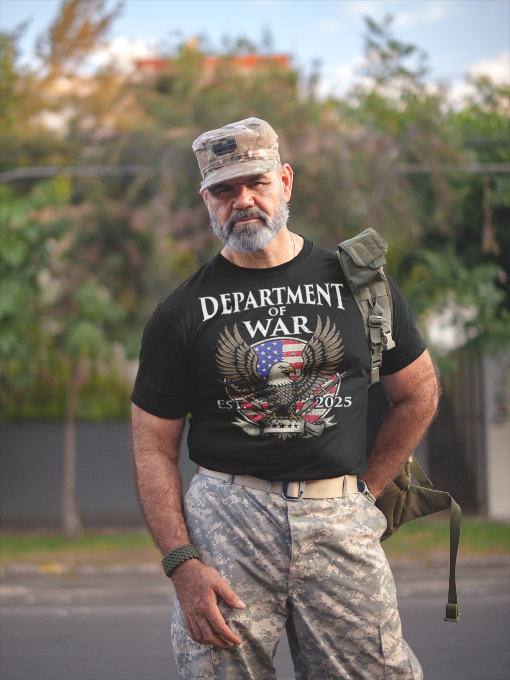 Man wearing Department Of War Graphic Design t-shirt with military camouflage pants and cap.