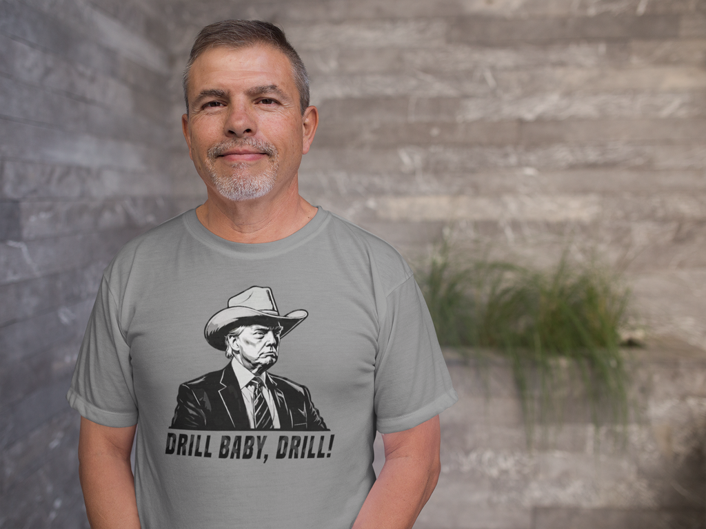 Man wearing a gray shirt with the phrase Drill Baby Drill Patriotic Graphic Tee and a graphic of a cowboy.