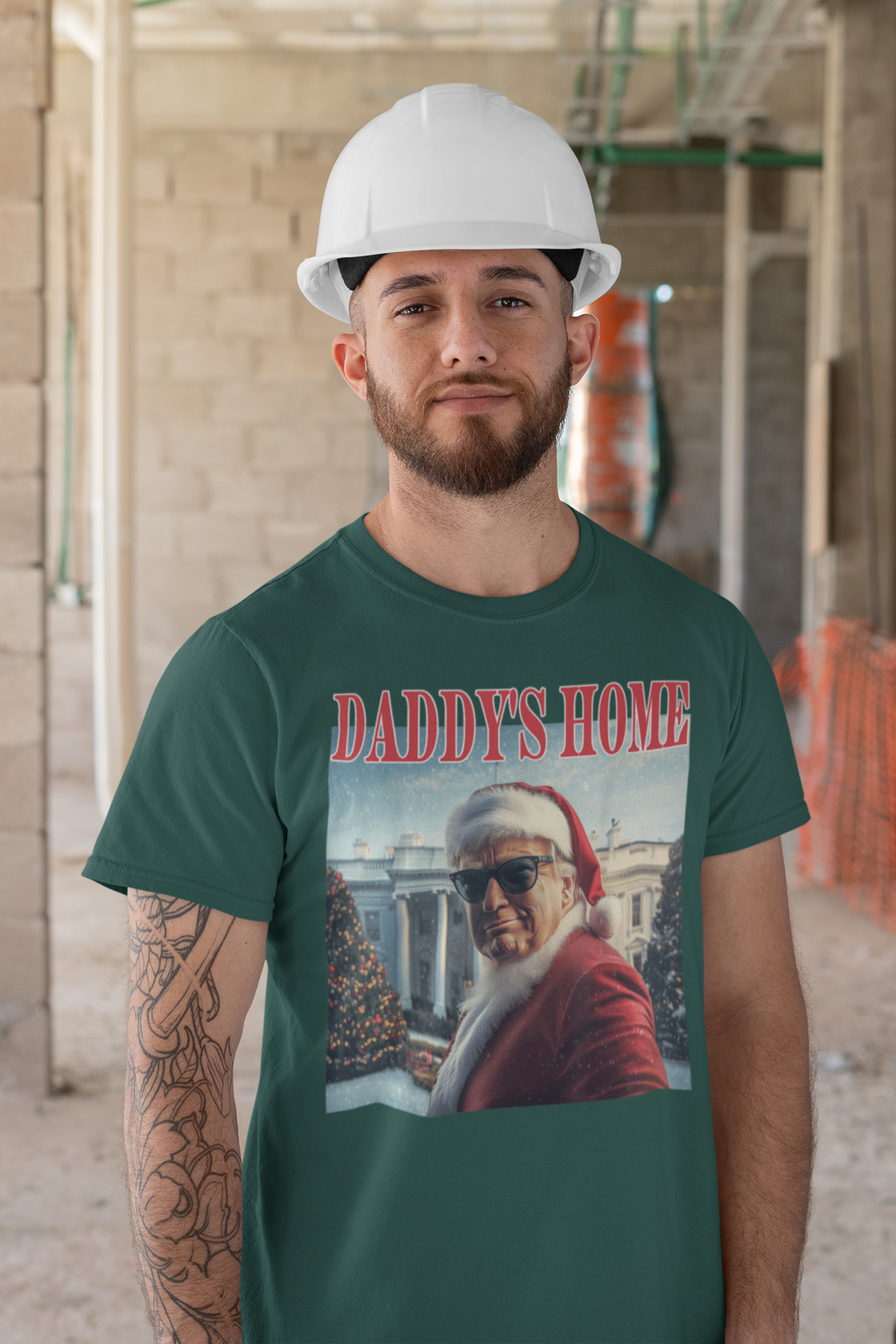 Man in green Daddy is Home Trump As Santa Tee with a hard hat in a construction site.