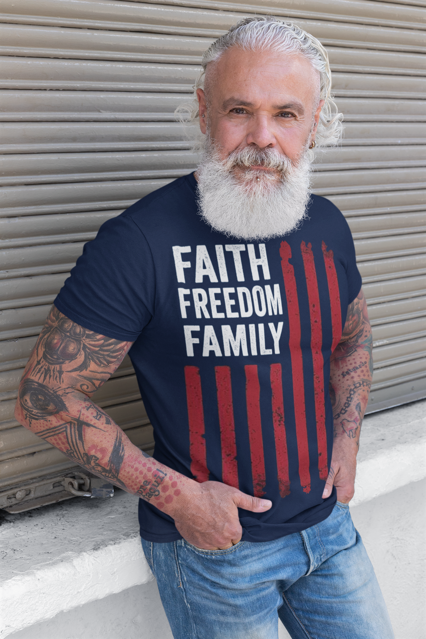 Man with beard wearing a FAITH FREEDOM FAMILY Timeless Values Graphic T Shirt against a striped wall.