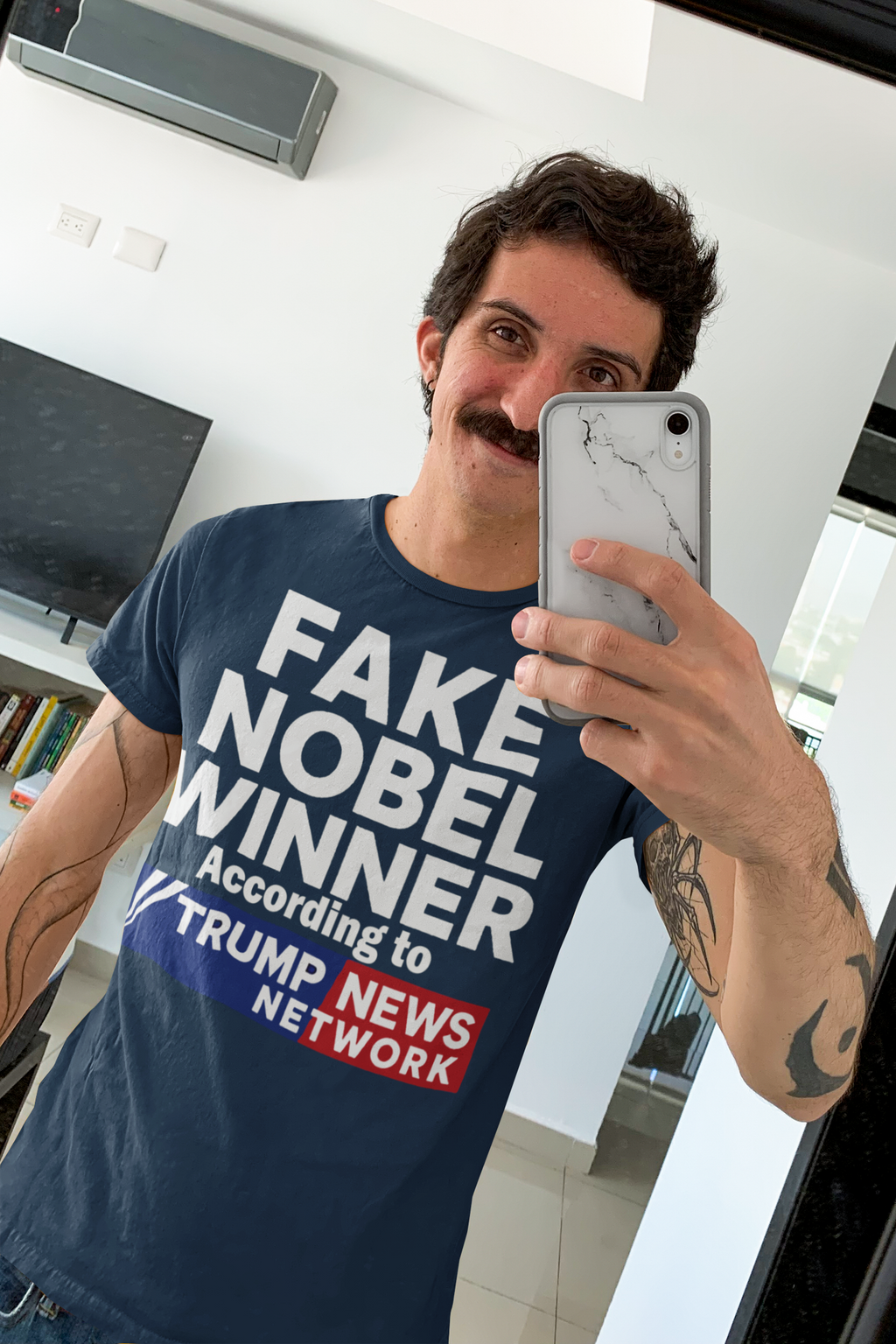 Person wearing a Fake Nobel Winner Graphic T-Shirt with humorous text design in casual setting.