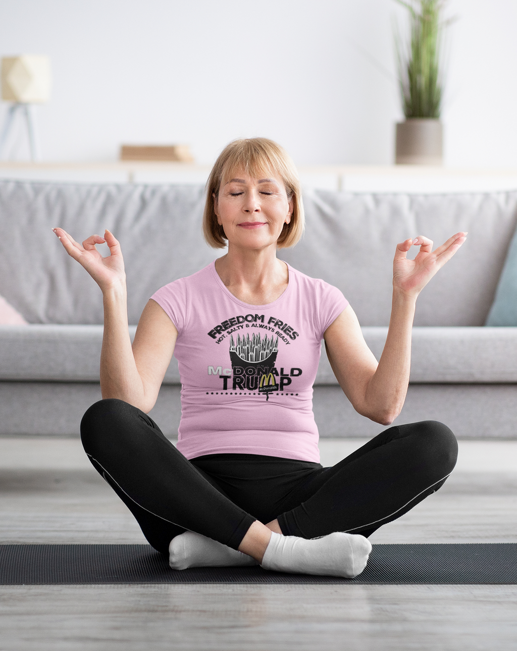 Woman practicing yoga in Freedom Fries Custom Art Graphic t-shirt with a peaceful expression in a cozy living room.