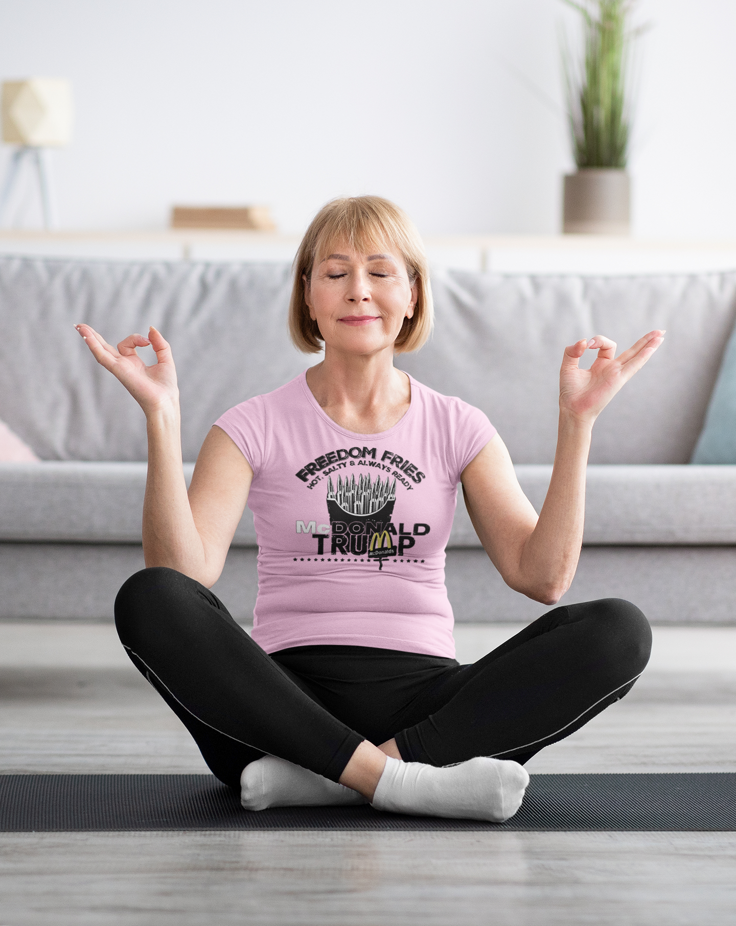 Woman practicing yoga in Freedom Fries Custom Art Graphic t-shirt with a peaceful expression in a cozy living room.