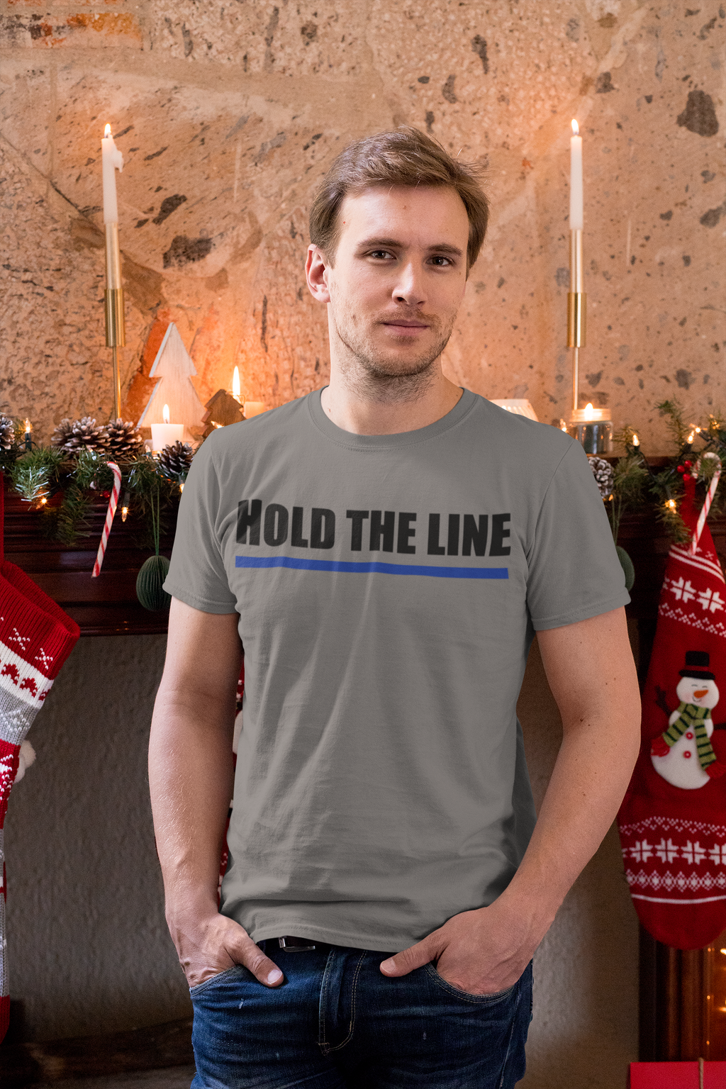 Man wearing a Hold The Line Black Letters T Shirt in a festive setting with Christmas decorations.