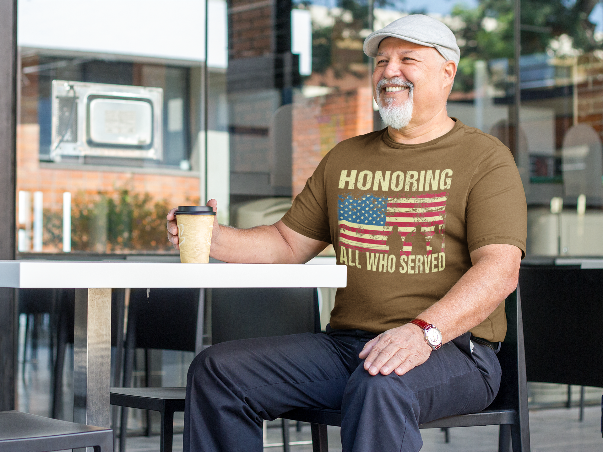 Man wearing Honoring All Who Served On American Flag t-shirt at a cafe, enjoying a coffee.