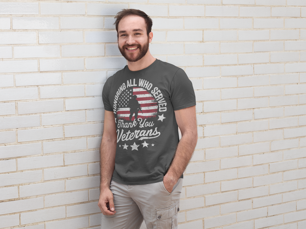Man wearing Honoring All Who Served Thank You Veterans graphic t-shirt, smiling against a white brick wall.