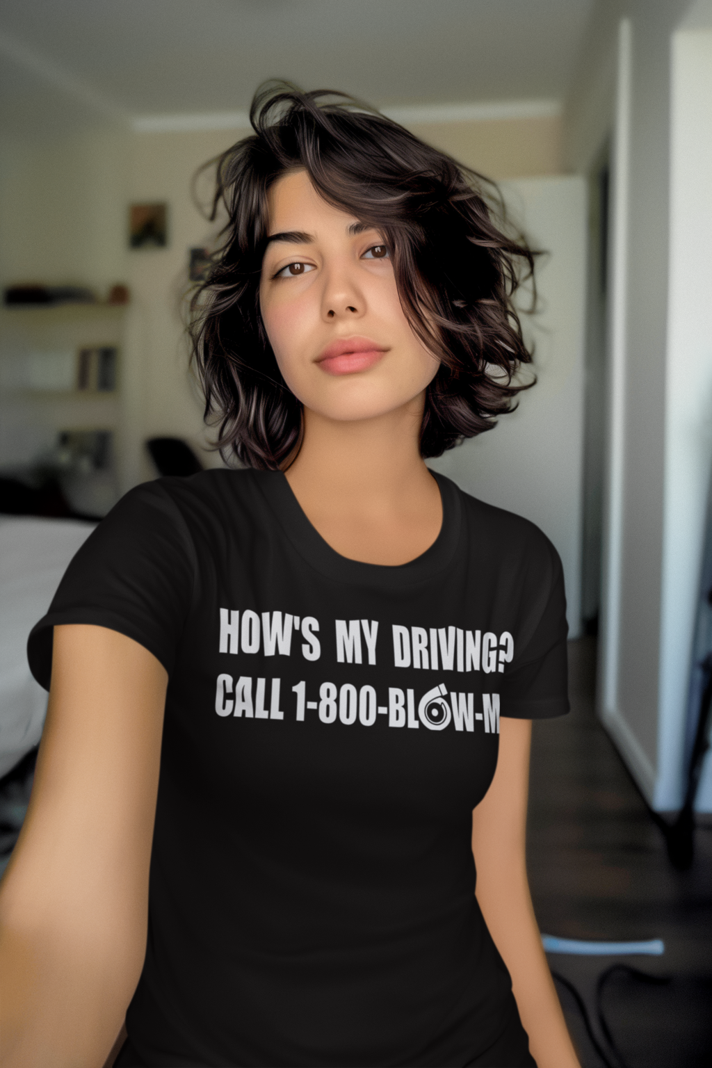 Woman wearing How is My Driving Novelty Car Tee with humorous driving message in a stylish room.