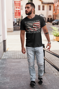 Man walking in a black t-shirt featuring the phrase It Offends You Until It Defends You Wht Ltrs with an American flag.