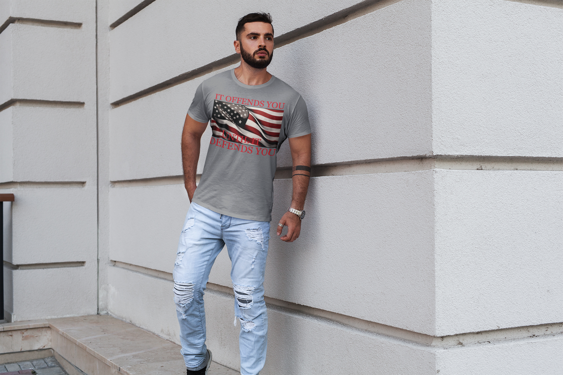 If Offends You Until It Defends You graphic tee with American flag design worn by a man outdoors.