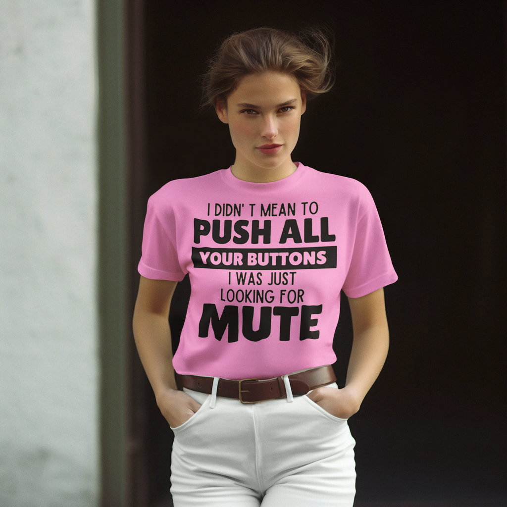 Woman wearing 'I Didn't Mean to Push Your Buttons Tee' in pink with humorous text in an outdoor setting.