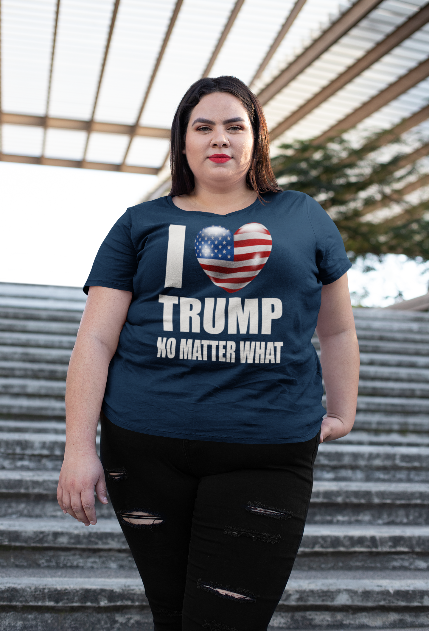 Woman wearing I Heart Trump No Matter What Tee while standing on outdoor stairs.