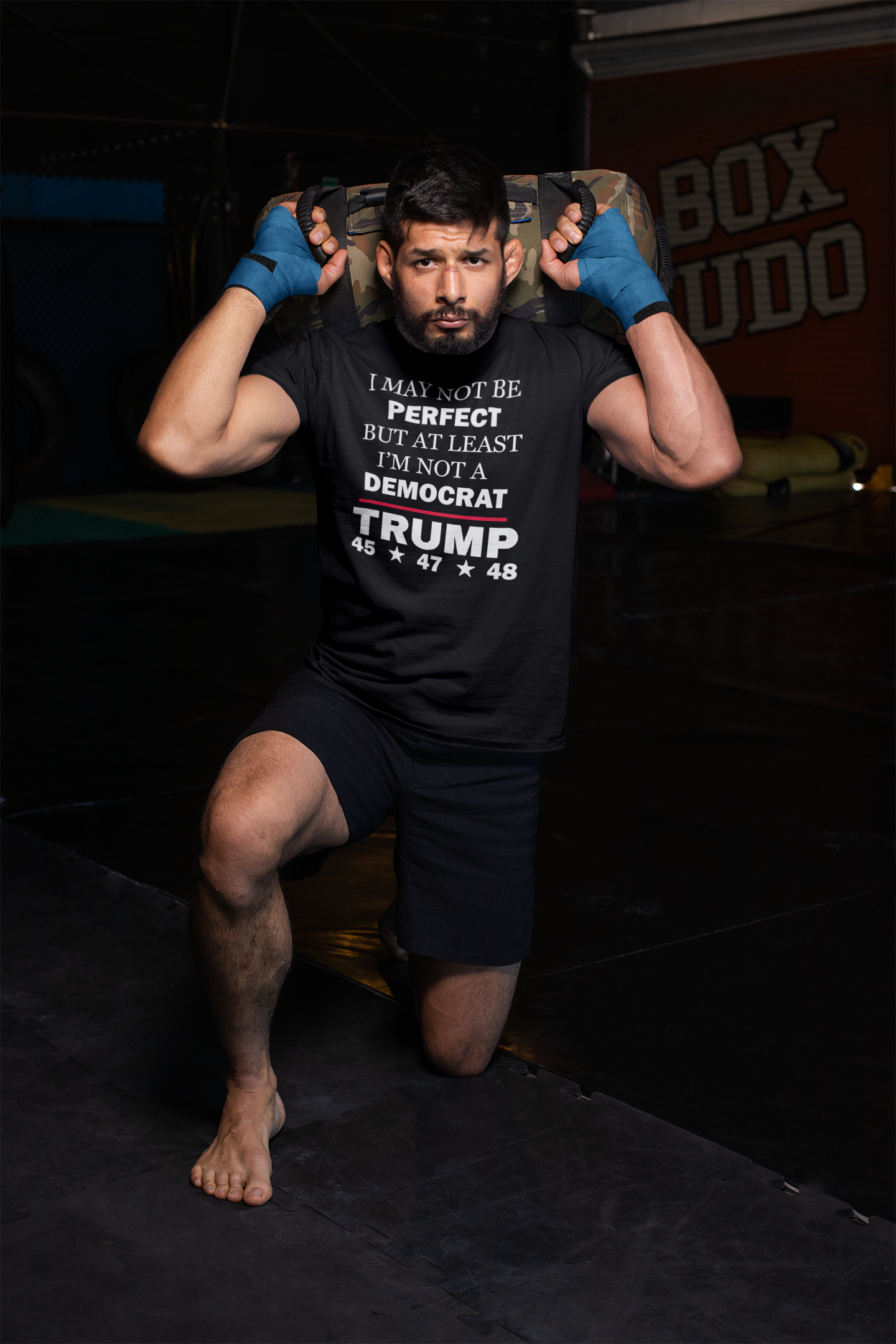A man in a gym wearing a shirt that says I May Not Be Perfect But At Least I'm Not A Democrat, showcasing a bold political message.