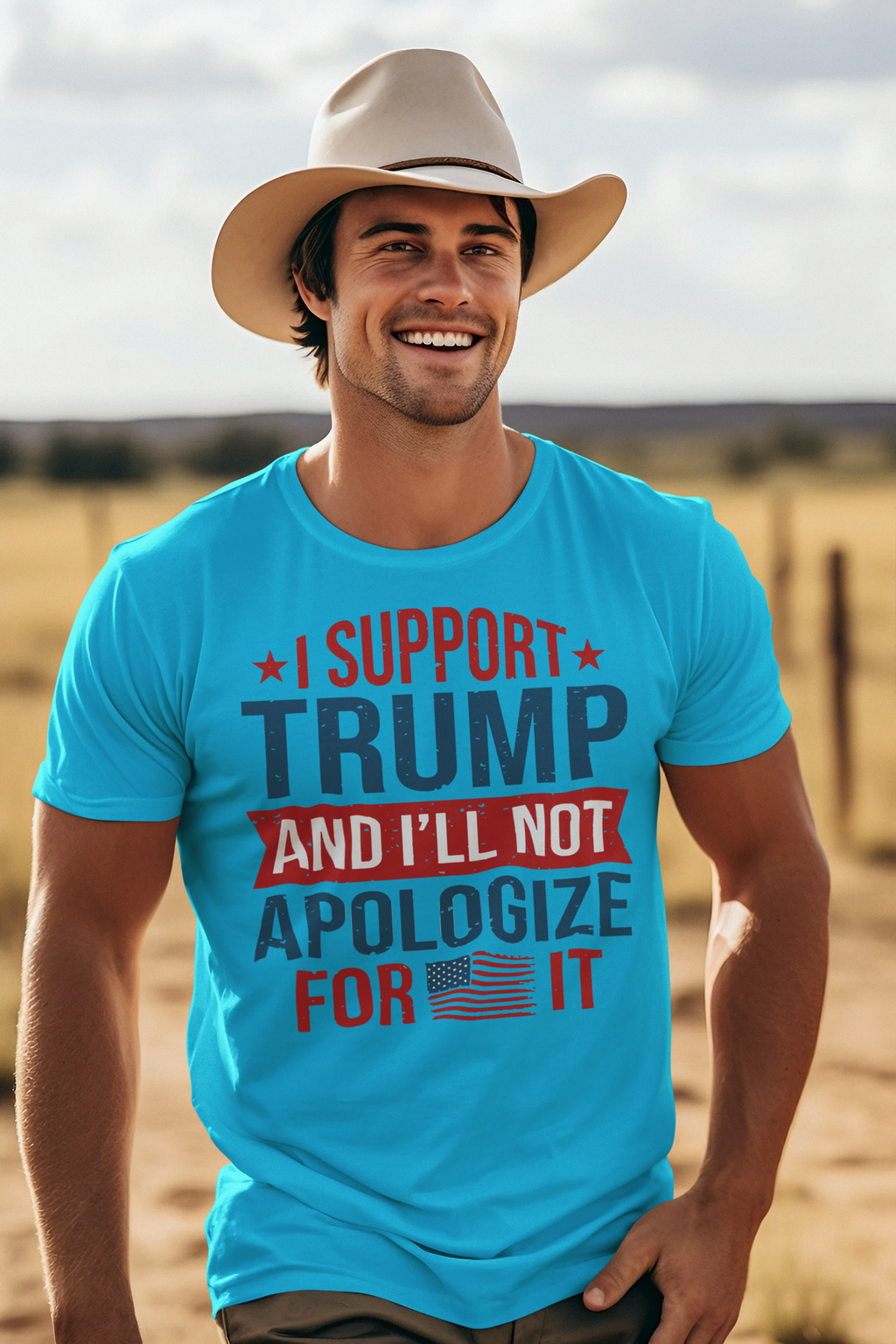 A confident man wearing a blue t-shirt that says I Support Trump And I'll Not Apologize For It in a sunny outdoor setting.