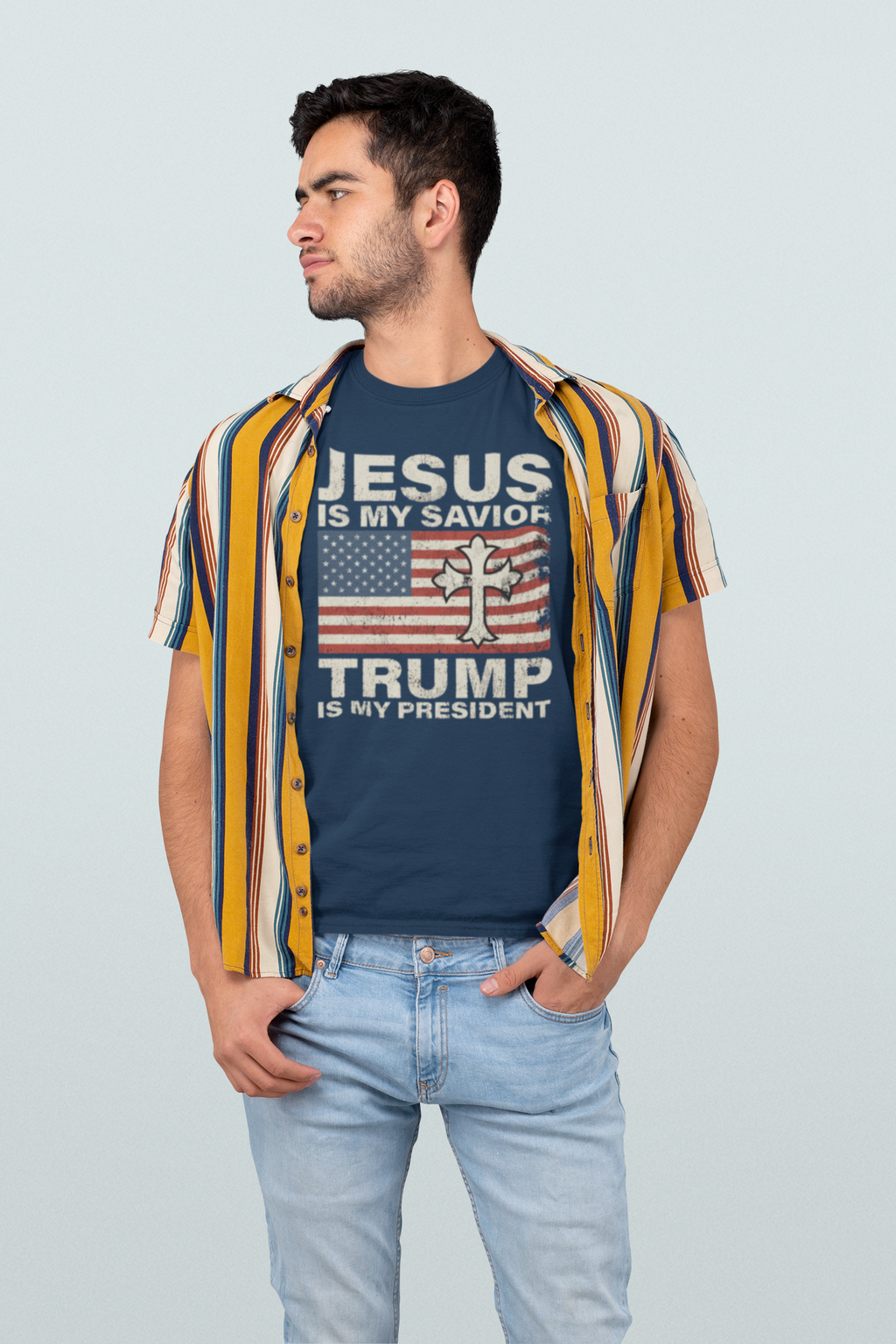 Young man wearing Jesus Is My Savior Trump Is My President t-shirt with patriotic design and striped shirt.