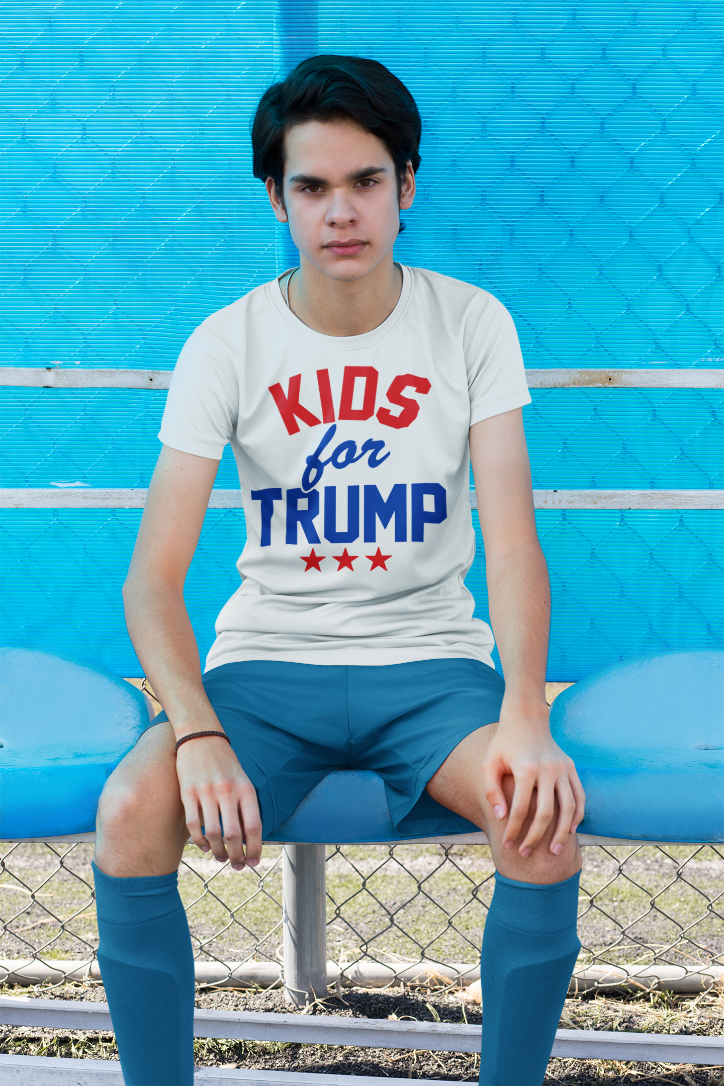 Young boy wearing a Kids for Trump USA Pride Shirt sitting on a bench, showcasing patriotic spirit.