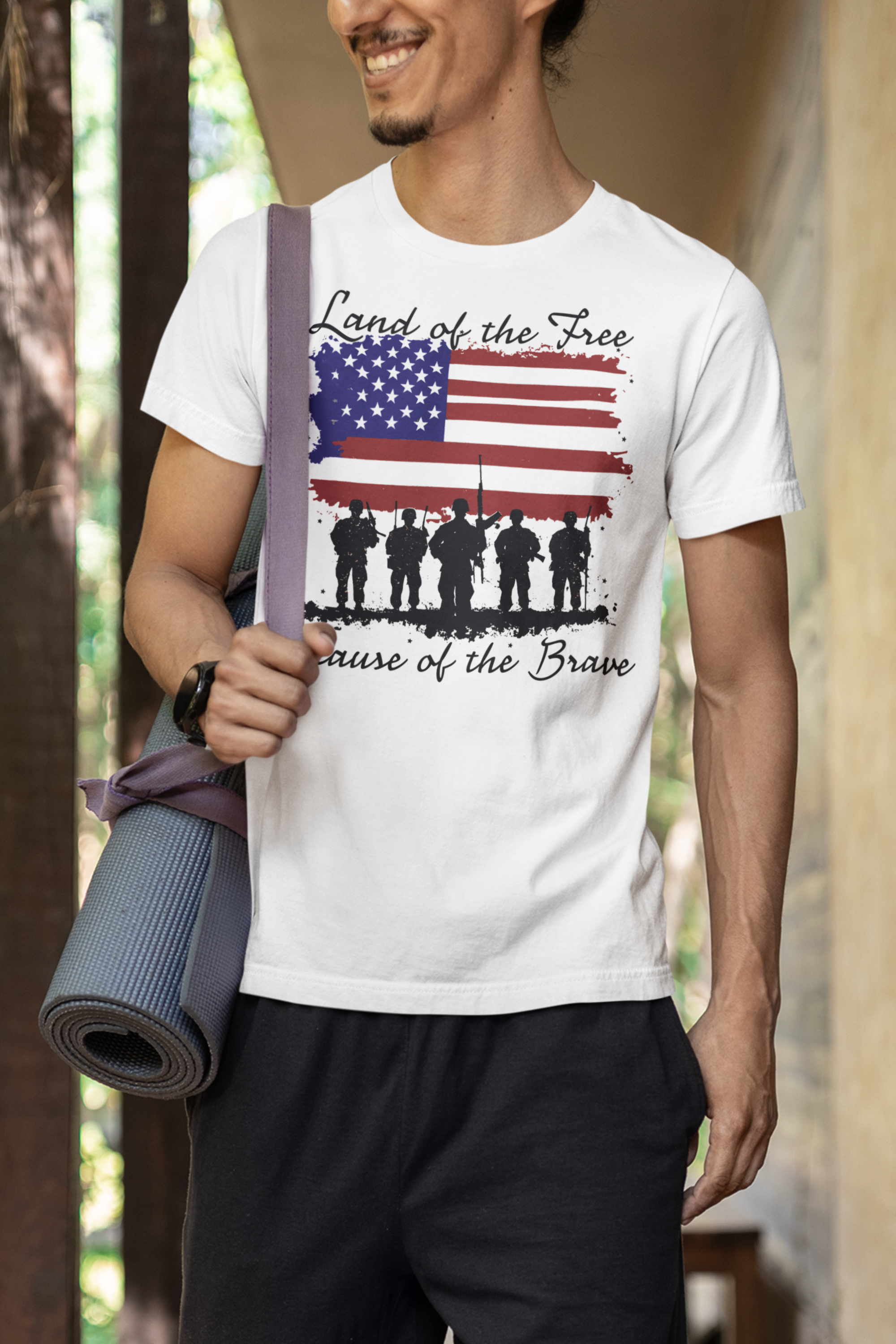 Man wearing Land Of the Free Because Of The Brave t-shirt with American flag design.