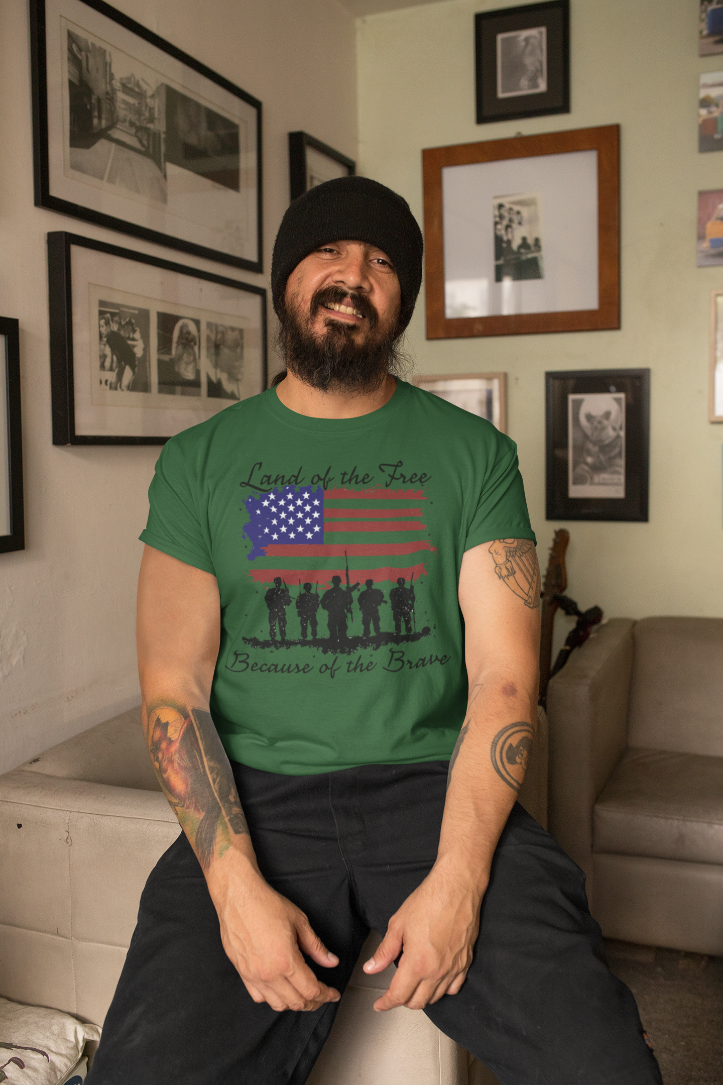 Man wearing a green t-shirt featuring the text 'Land of the Free Because of the Brave' with an American flag design.