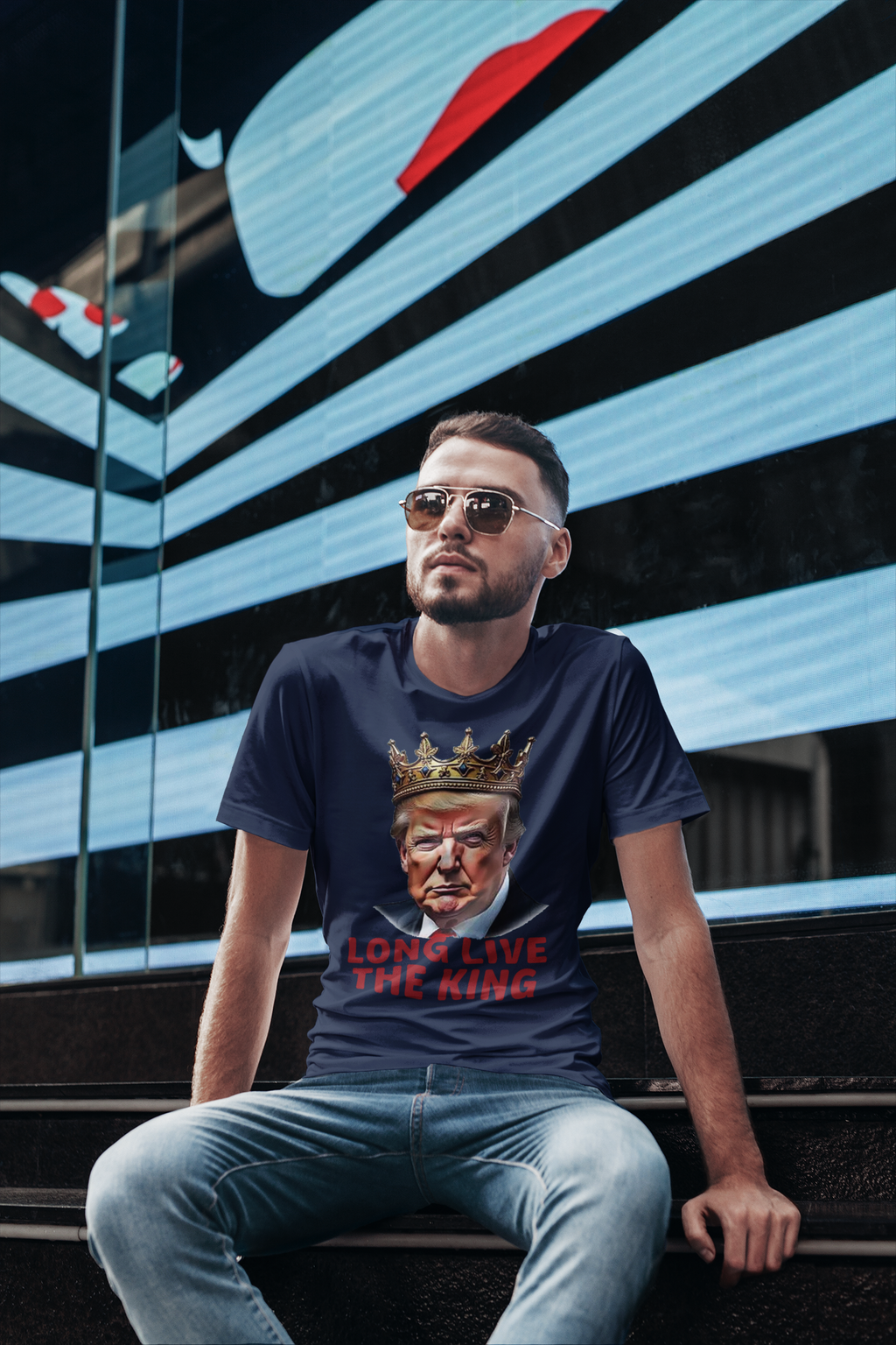 Man wearing a Long Live the King Vintage Shirt with a crown design, sunglasses, and urban backdrop.