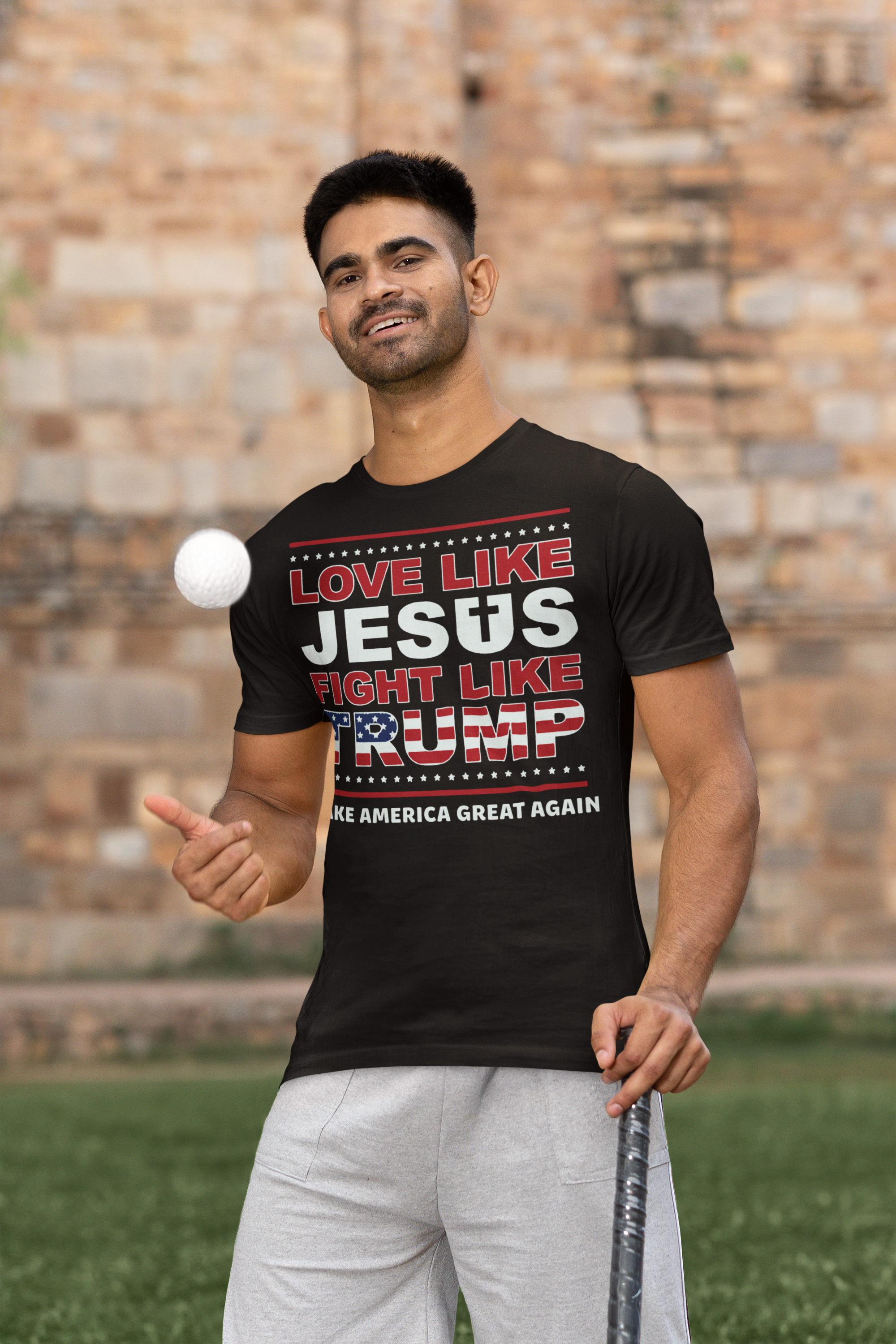 Love Like Jesus Fight Like Trump t-shirt worn by a man playing with a baseball outdoors.