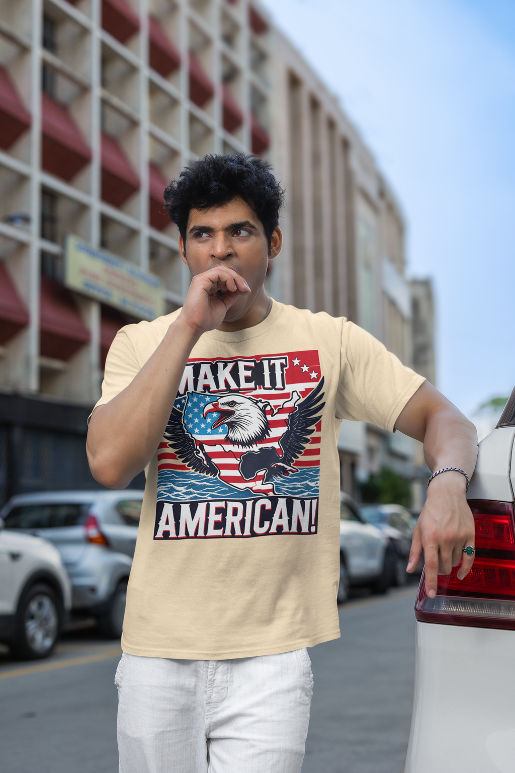 A man wearing a Make It American American Pride Shirt with an eagle design on a city street.