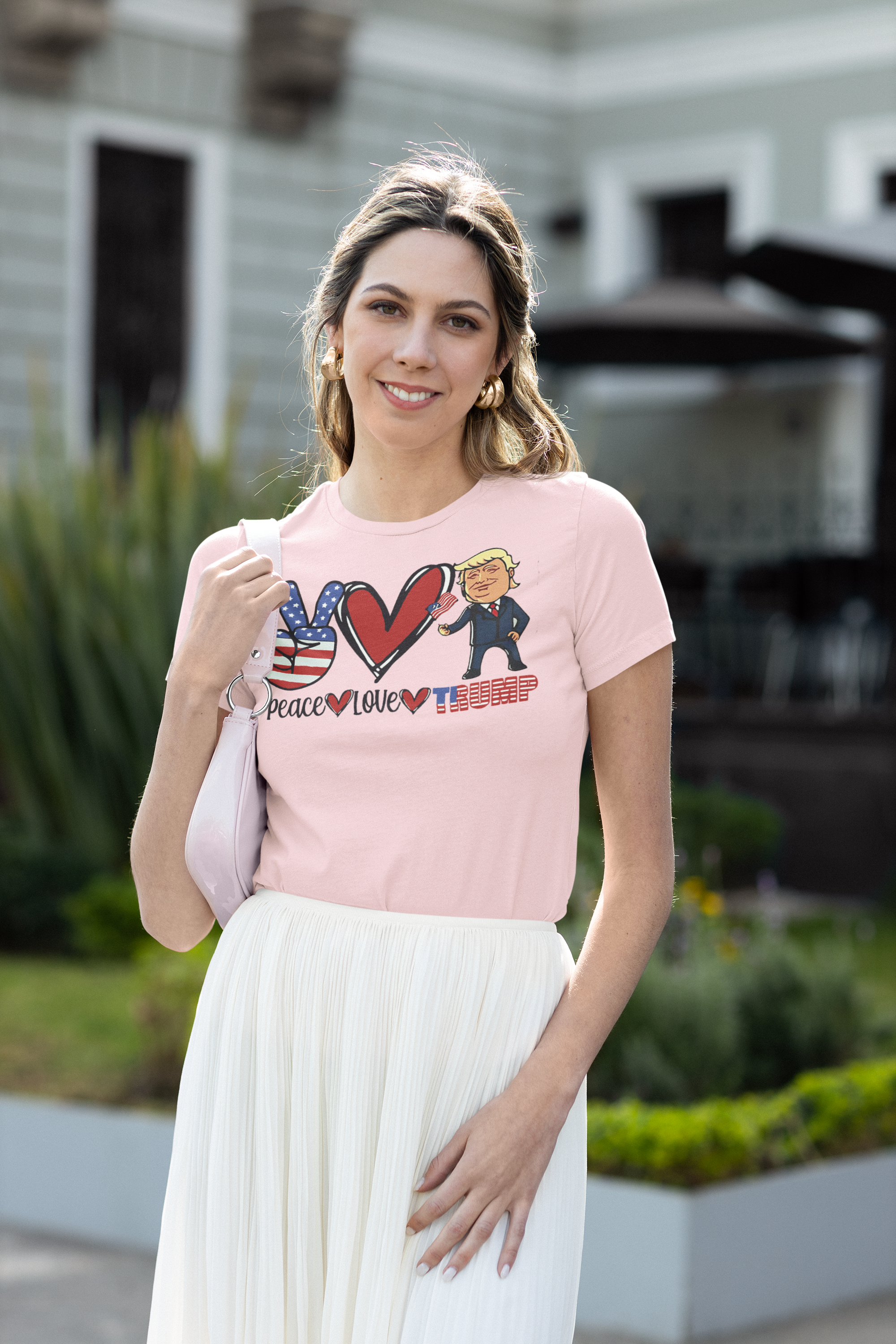 Woman wearing a pink shirt with Peace Love Trump Patriotic Design graphic outdoors.