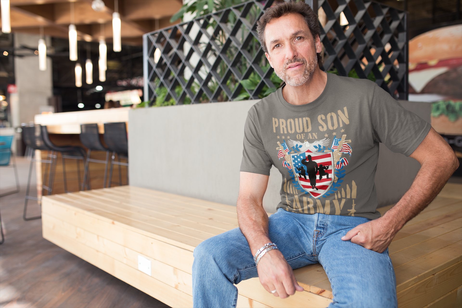Man wearing a Proud Son of an Army Veteran Design t-shirt in a casual setting, showcasing military pride.