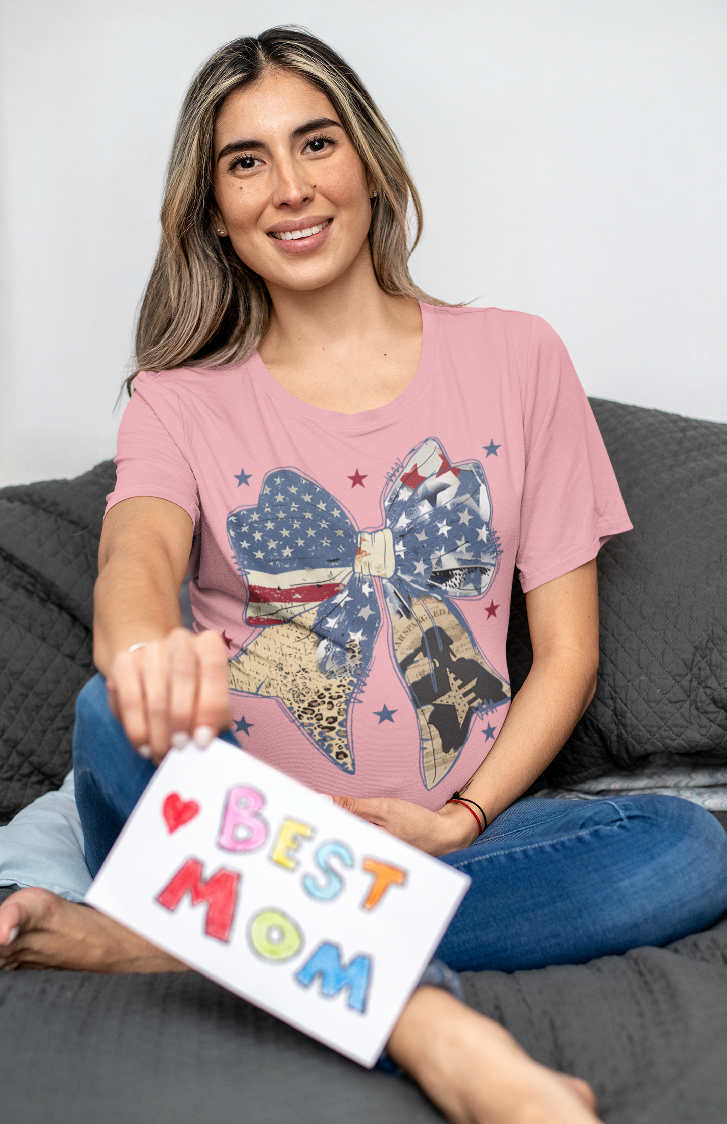Ribbon As American Flag With Saluting Soldier design on pink t-shirt, woman holding 'Best Mom' card.