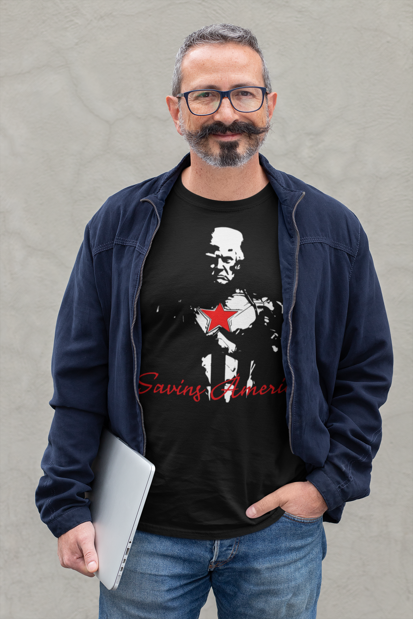 Man wearing a Saving America Graphic Design Tee with a patriotic graphic design and a laptop.