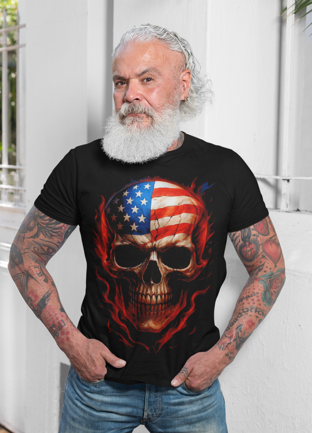 Punisher In Stars And Stripes Aflame graphic t-shirt worn by a bearded man with tattoos, showcasing a patriotic design.