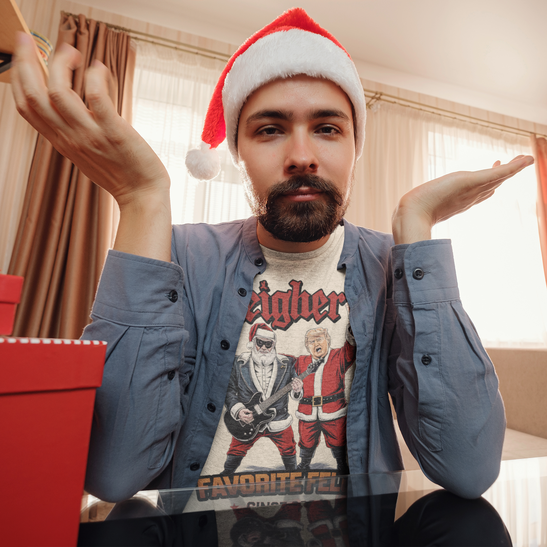 Man wearing Santa hat and Sleigher's Favorite Felon Since 2024 t-shirt, looking playful with gift boxes nearby.