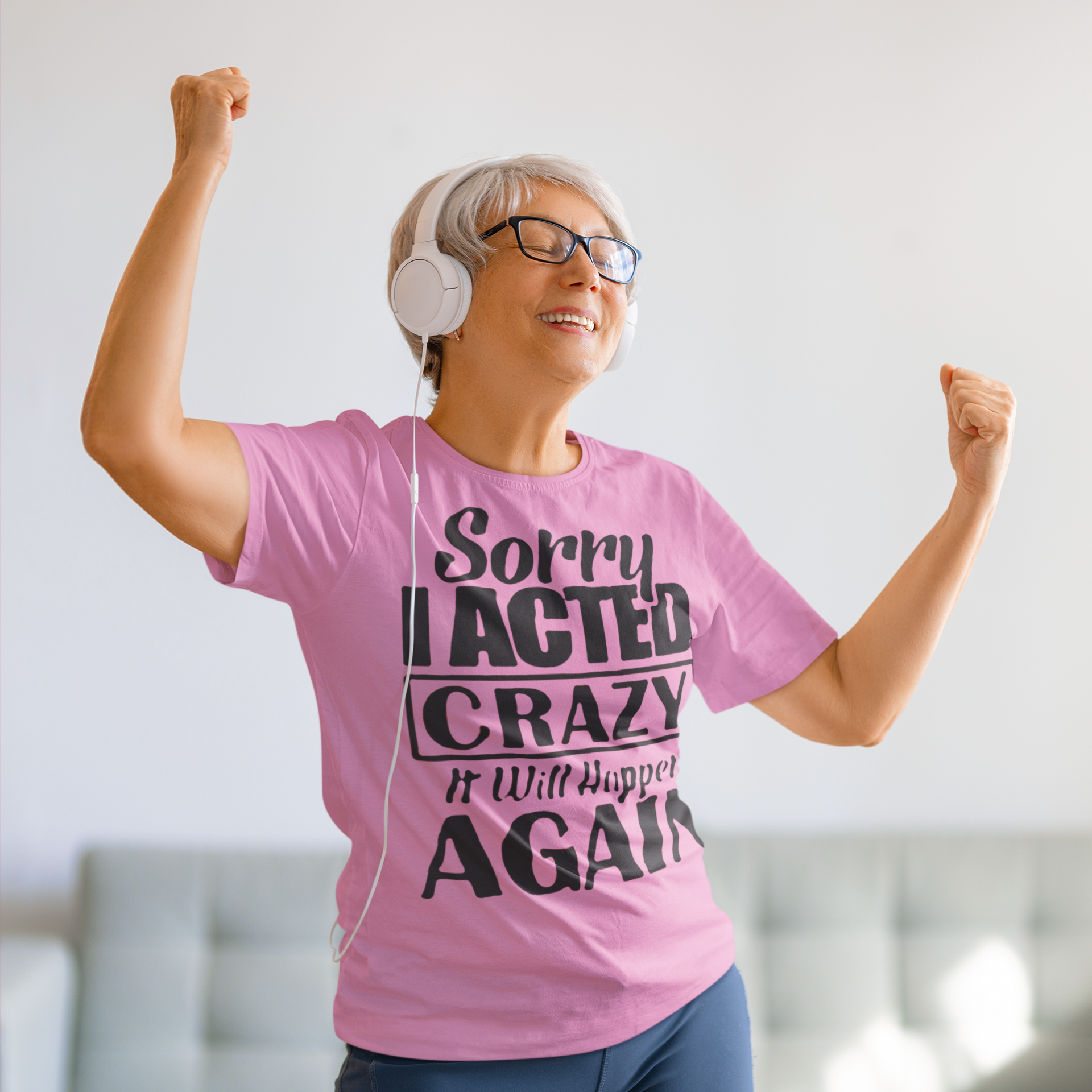 Woman wearing Sorry I Acted Crazy Funny Statement Tee with headphones, expressing joy.
