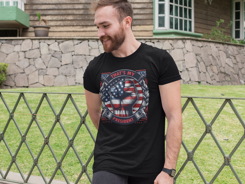 That's My President Fist In Stars And Stripes t-shirt worn by a smiling man, showcasing patriotic design.