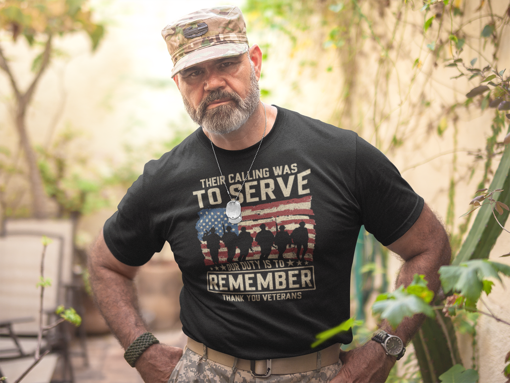 Their Calling Was To Serve Our Duty Is To Remember merchandise worn by a veteran in a garden setting.