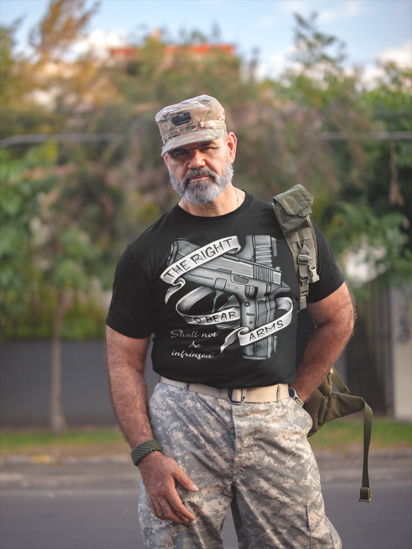 A man in military attire wears a shirt featuring the phrase The Right To Bear Arms Shall Not Be Infringed.