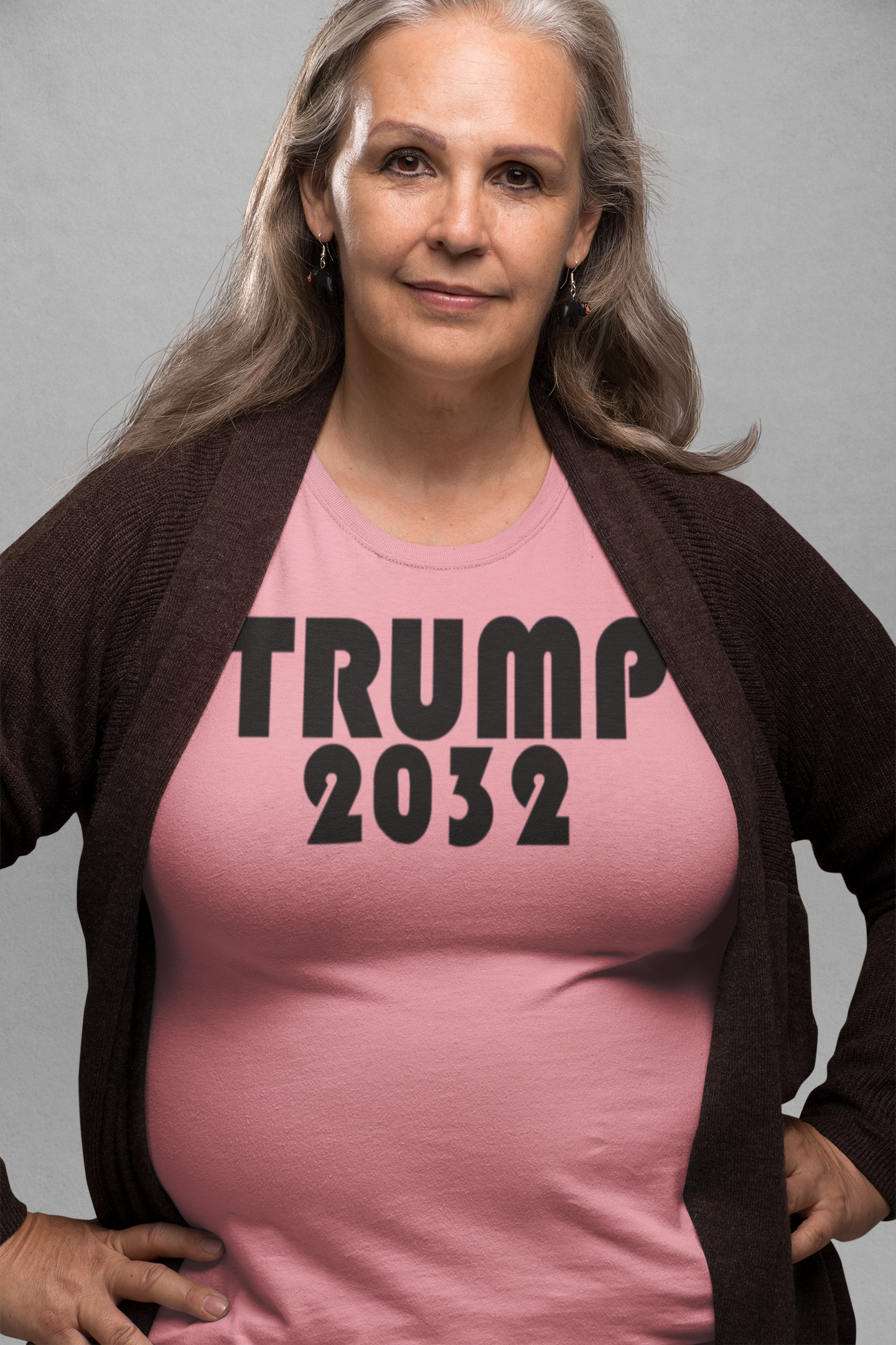 Woman wearing a pink shirt with bold lettering reading 'TRUMP 2032', promoting the Trump 2032 Red Print Style Gear.