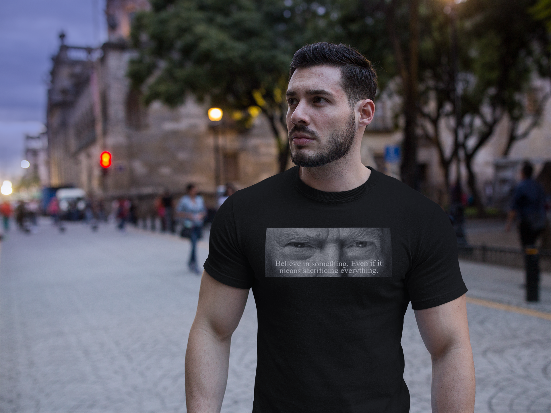 Man wearing Believe In Something Even If It Means Sacrificing Everything graphic tee in urban setting.