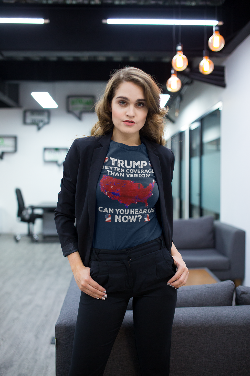 Model wearing Trump Better Coverage Than Verizon graphic tee in modern office setting.