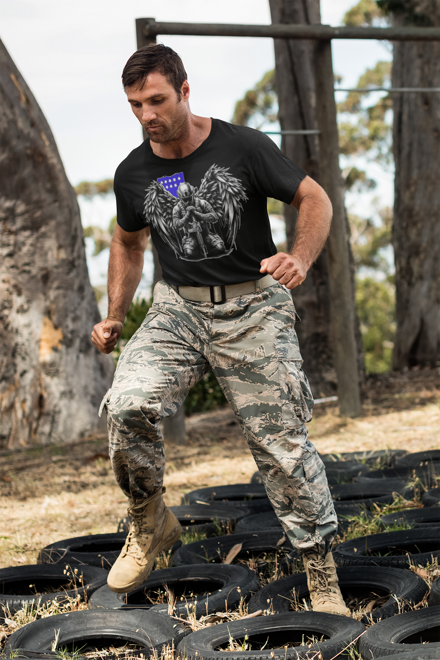 Man wearing Stylish Veteran With Wings Tee and military pants, training on tires outdoors.