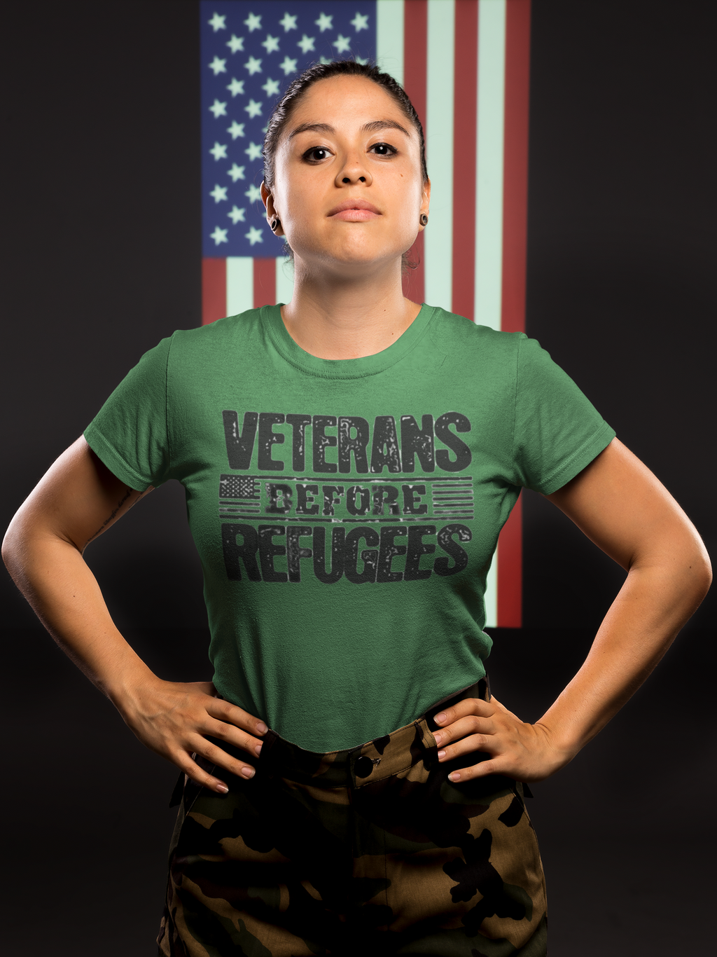 Woman wearing Veterans Before Refugees Apparel t-shirt, standing confidently in front of an American flag.