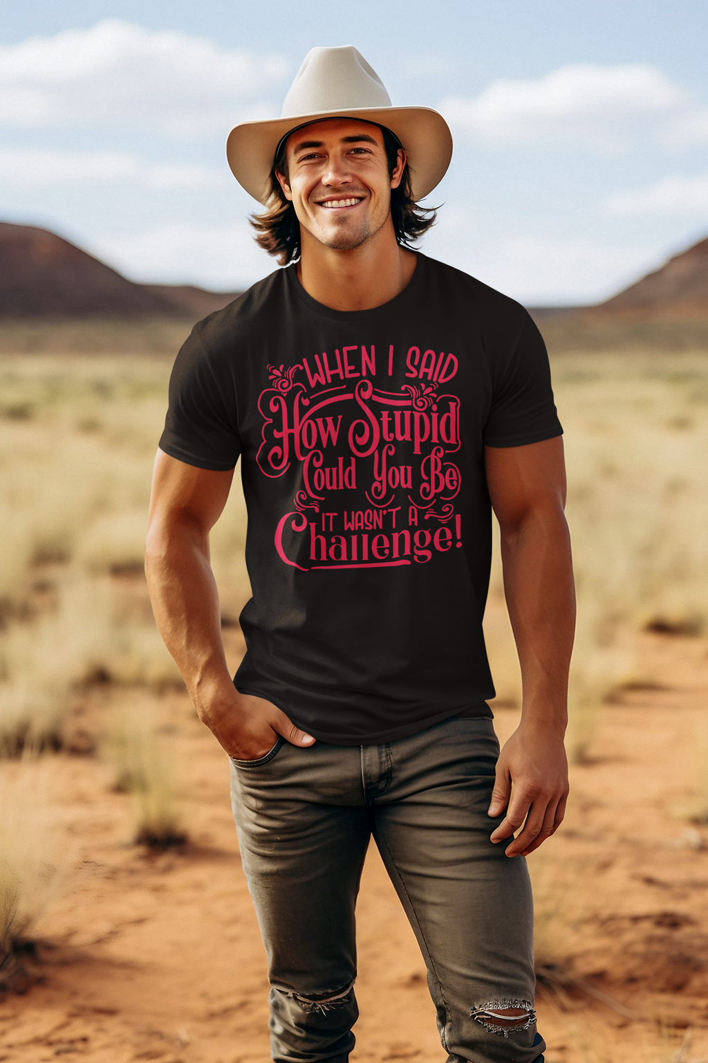Man wearing 'When I Said How Stupid Could You Be It Wasn't A Challenge' t-shirt in desert landscape.