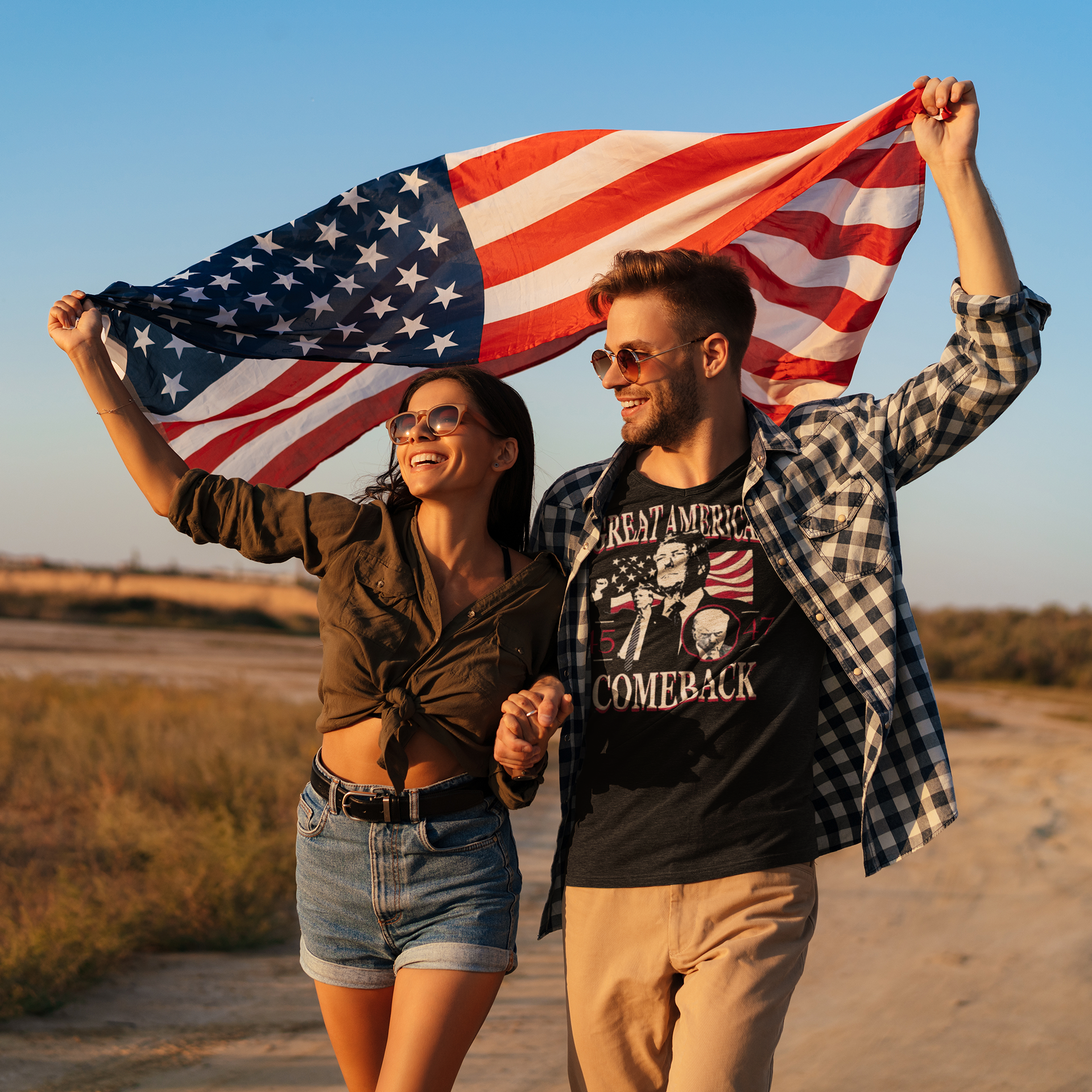 Couple celebrating with an American flag wearing Great American Comeback 45 47 T Shirt in a scenic outdoor setting.
