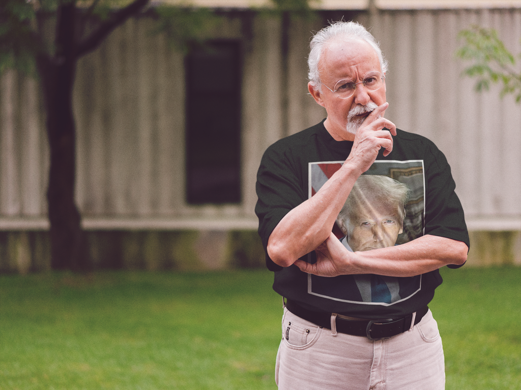Serious Trump Portrait Graphic tee worn by a man in a park, showcasing his support for personal values.